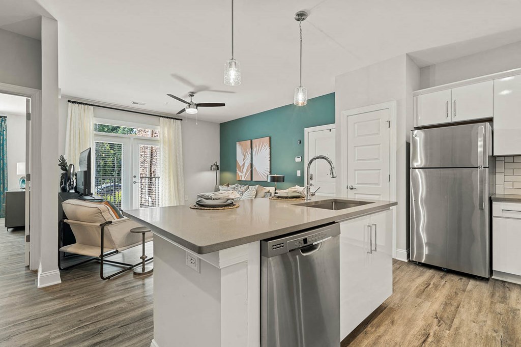 a kitchen with a large island and a stainless steel refrigerator
