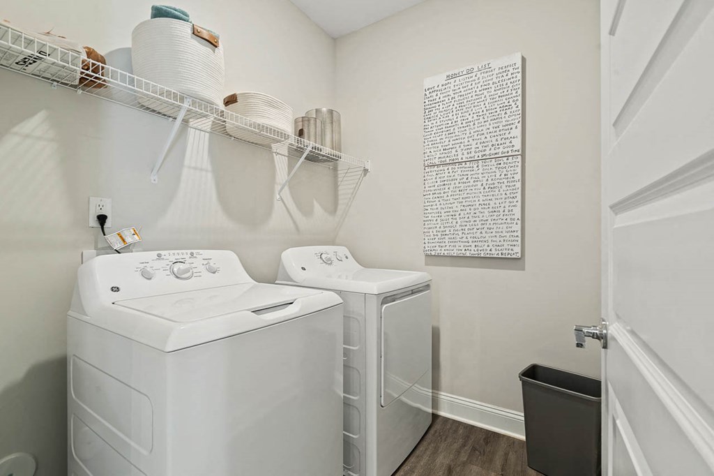 a white laundry room with a washer and dryer and a sink