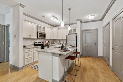 a kitchen with white cabinets and a marble counter top