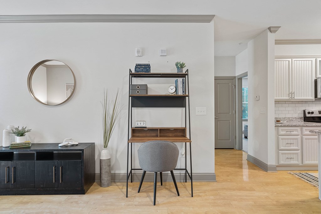 a living room with a desk and a chair and a shelving unit