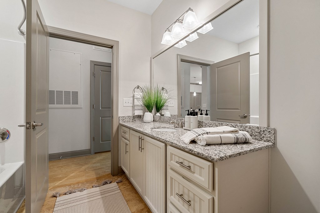 a bathroom with a sink and a shower and a mirror