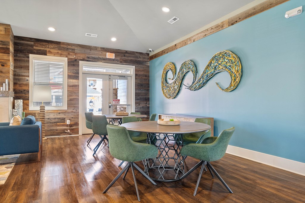Amenities a dining room with a table and chairs and a blue wall with an abstract painting