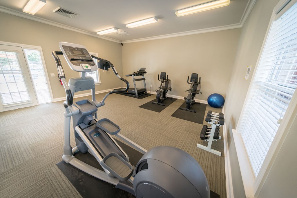 a gym with cardio equipment and weights at the belgard apartments