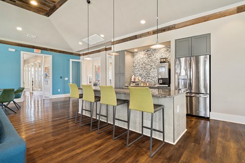 a kitchen with a large island with yellow chairs