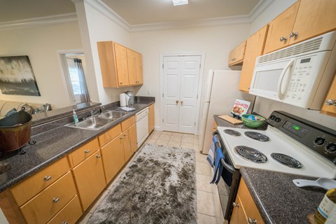 a kitchen with a stove and sink and a refrigerator