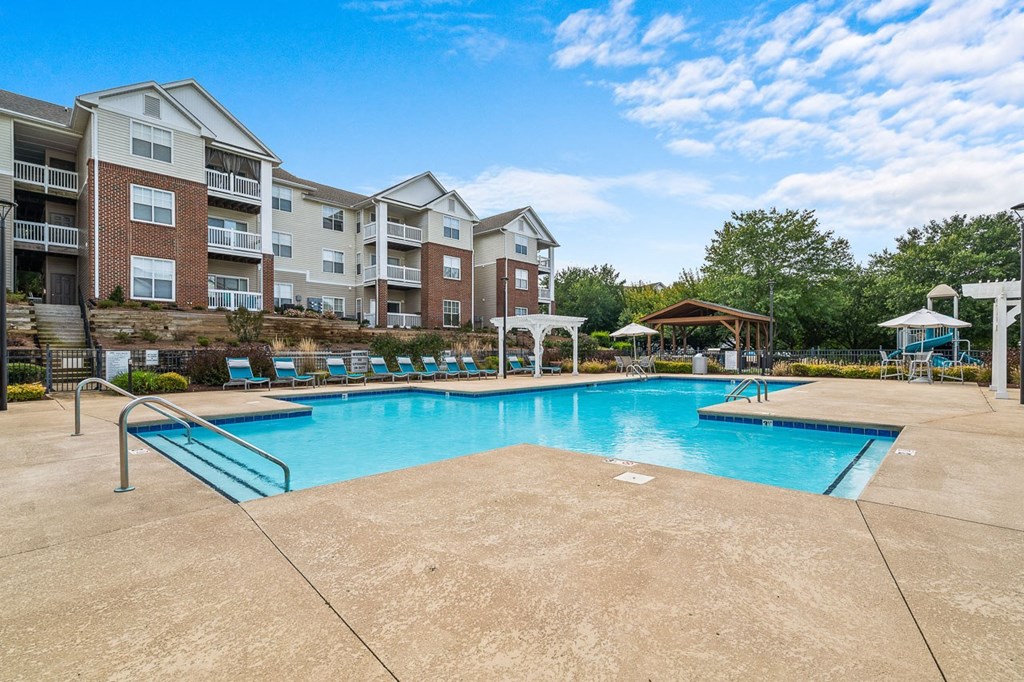a swimming pool with an apartment building in the background