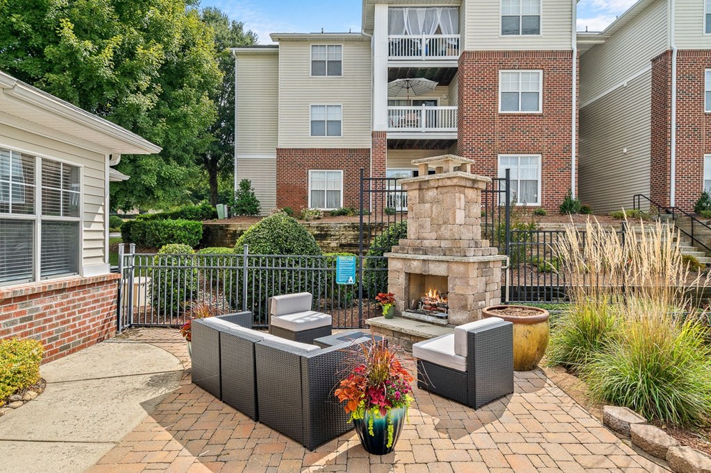 a courtyard with a stone fireplace and a patio with furniture