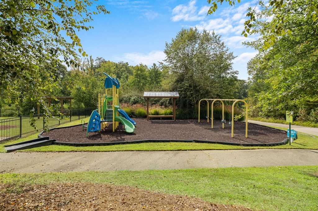 a playground with a slide and swing set in a park