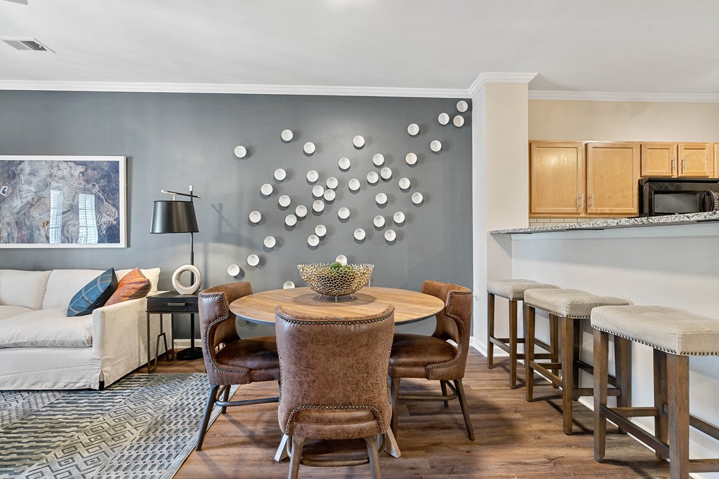 a living room with a table and chairs and a kitchen