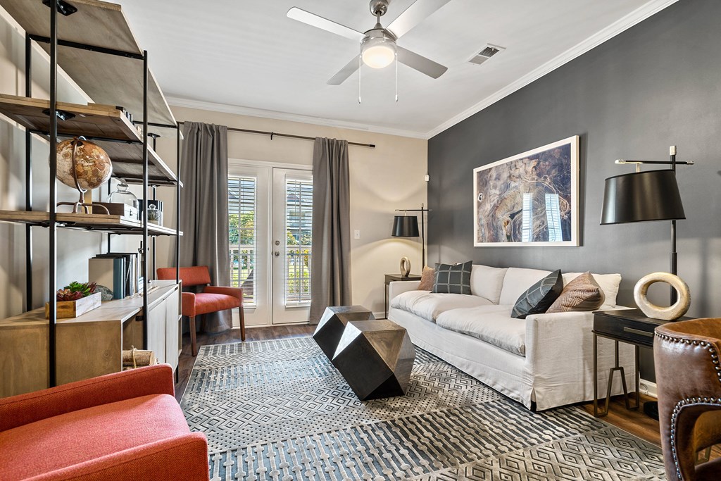 a living room with a white couch and a ceiling fan