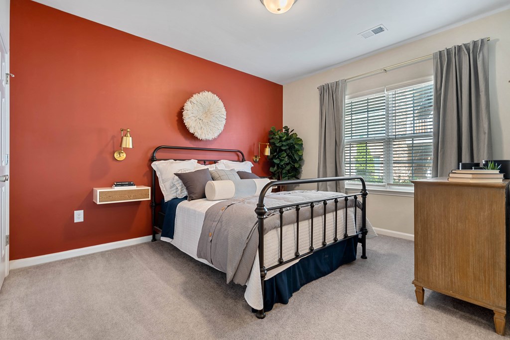 a bedroom with a bed and a dresser and a window