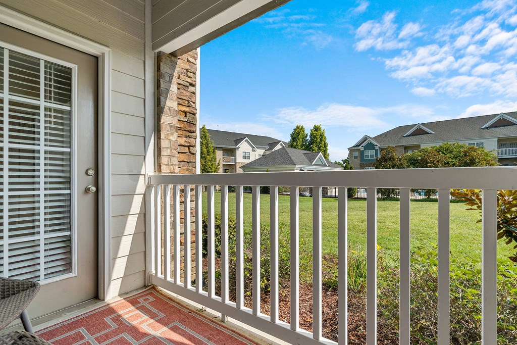 a balcony with a view of a yard and houses