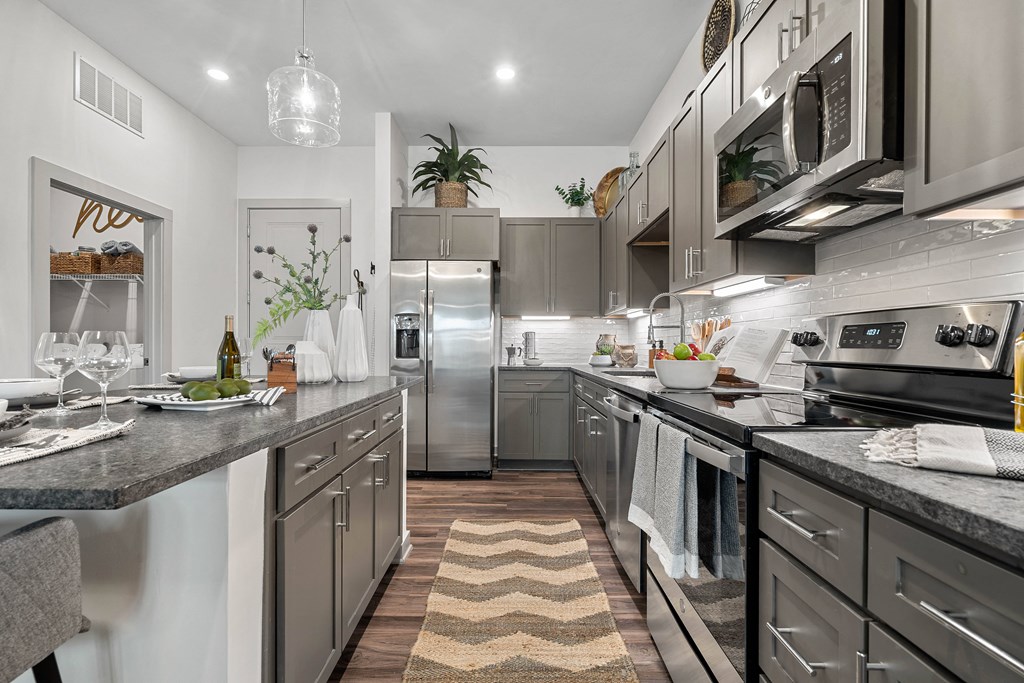 a kitchen with stainless steel appliances and gray counters