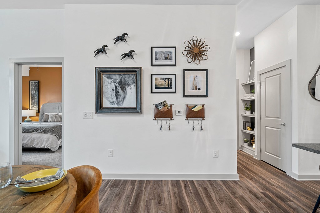 the living room and dining room of a house with white walls and a wooden table