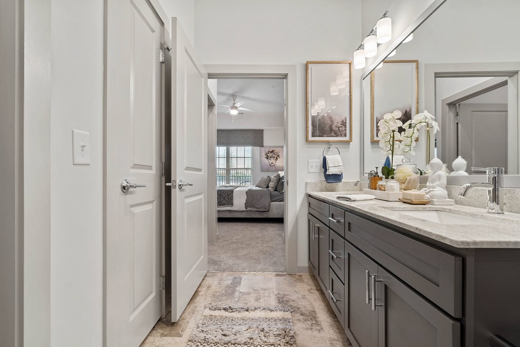 a bathroom with a sink and a door to a bedroom