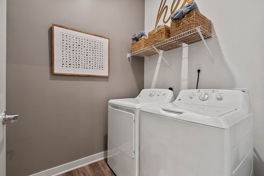 a white washer and dryer in a laundry room with a basket on top
