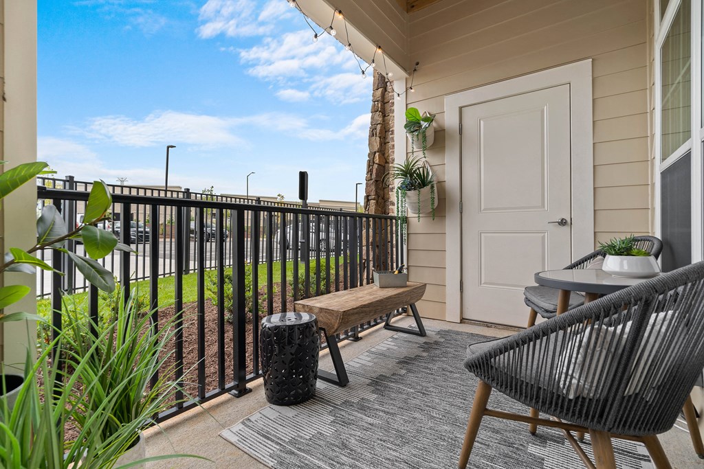 a balcony with a chair and a table and a door