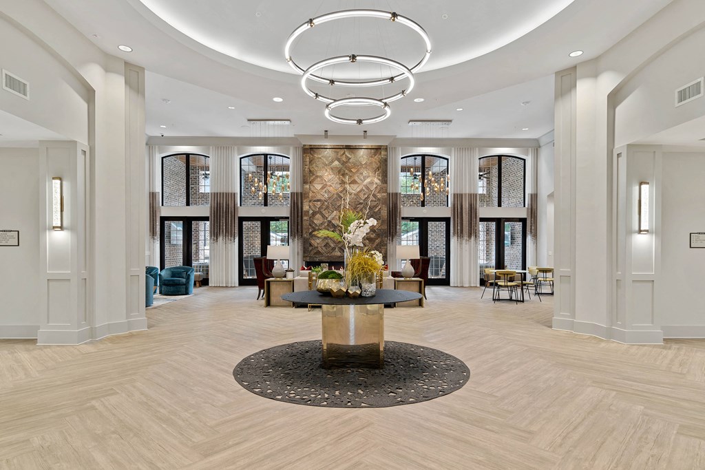 a large lobby with a large chandelier and a table with flowers
