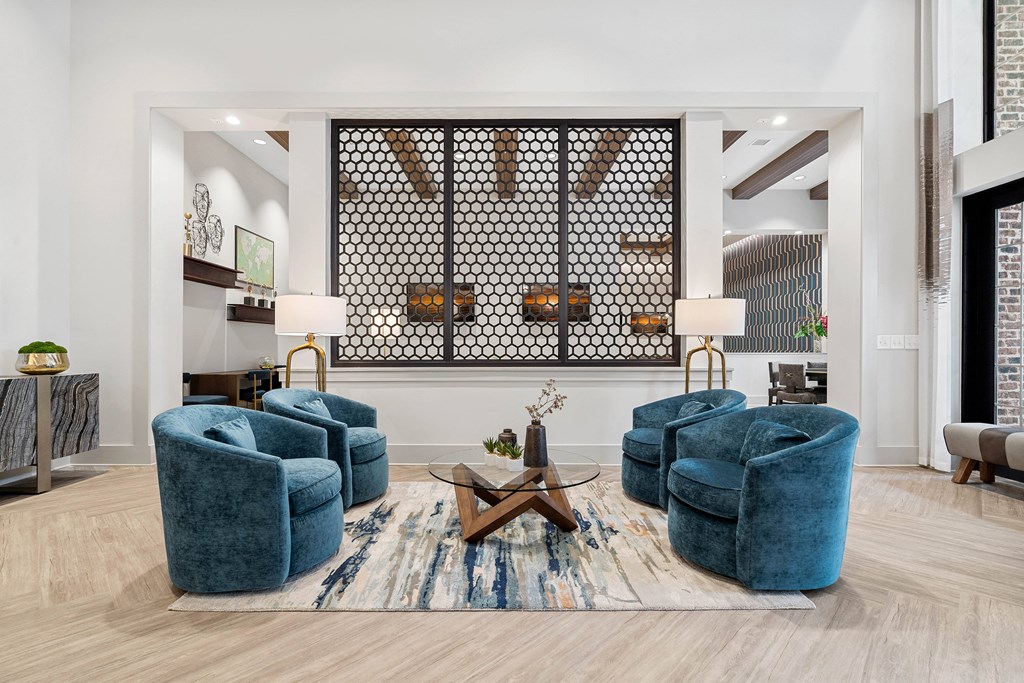 a living room with blue chairs and a rug