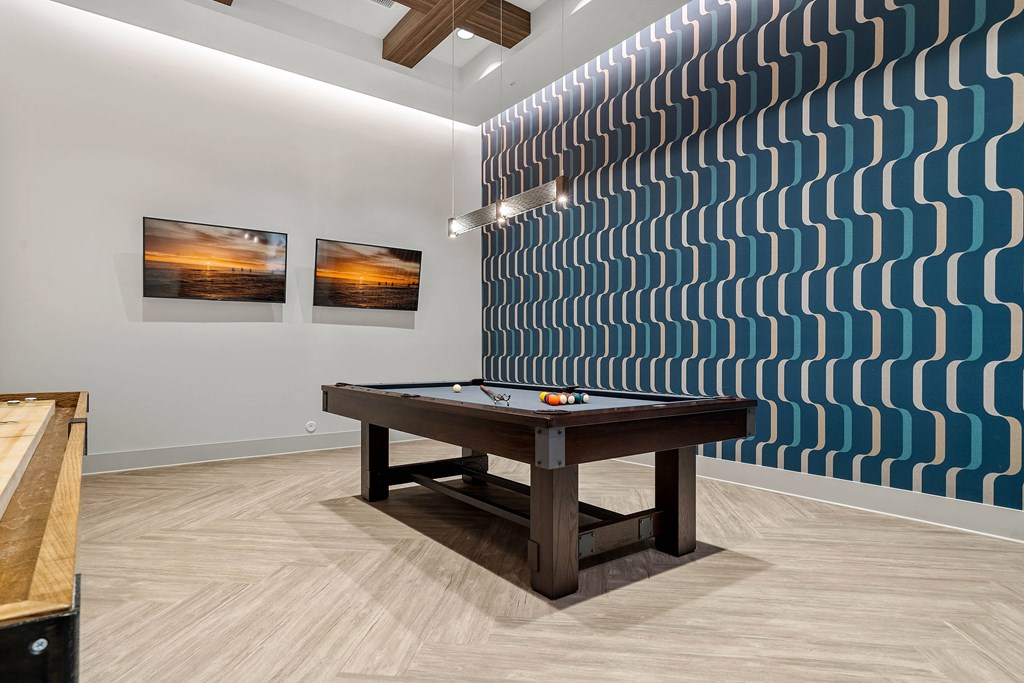 a game room with a pool table and a wall with a geometric design