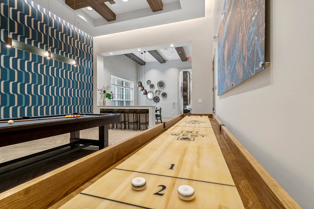 a bowling alley in a game room with a shuffleboard table