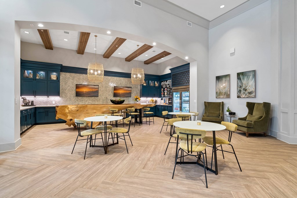 a communal area with tables and chairs and a kitchen