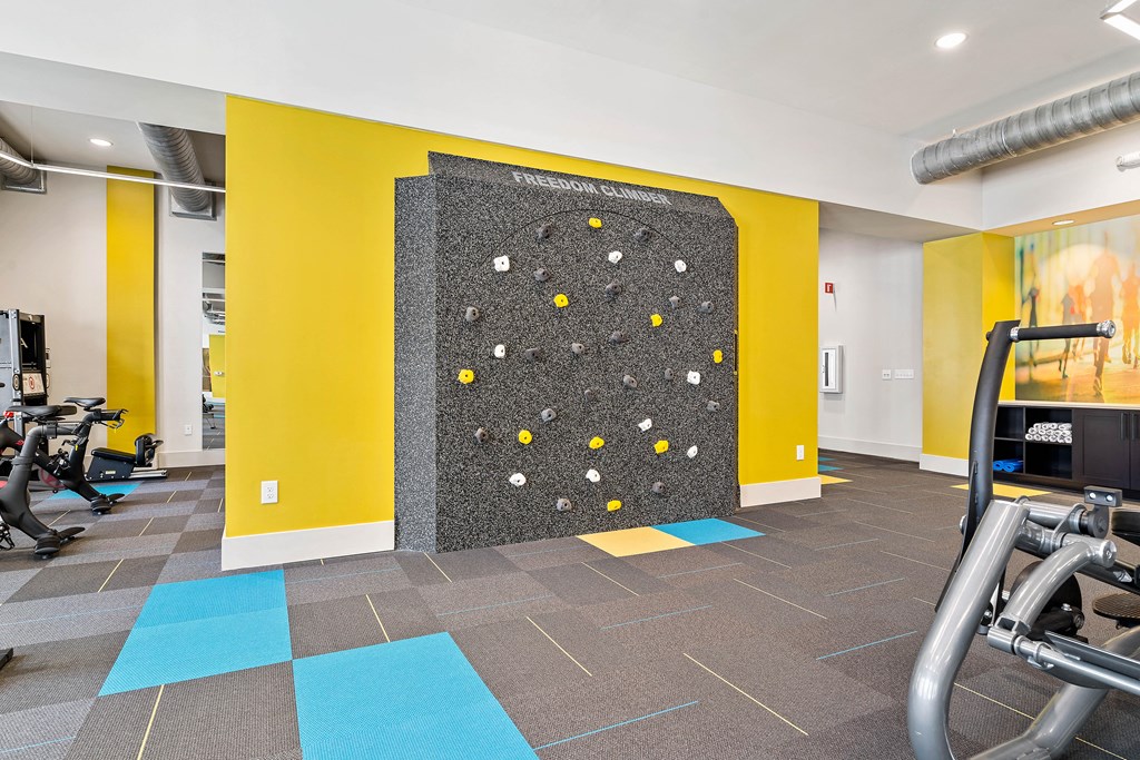 a gym with a large wall with a climbing wall in the center