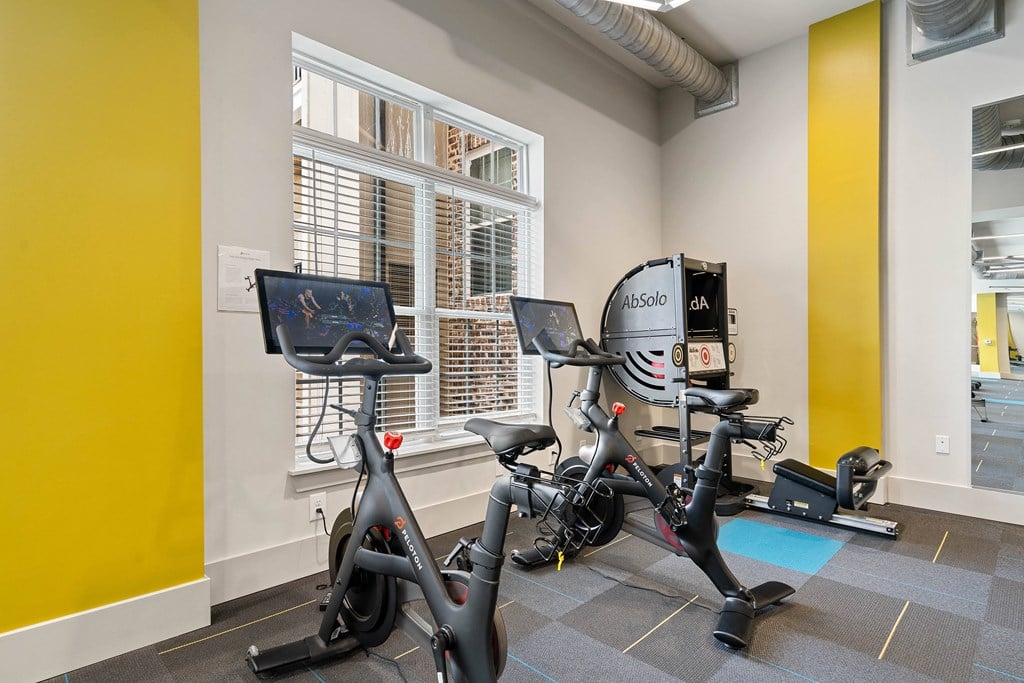 a gym with exercise equipment at the district at highland village apartments