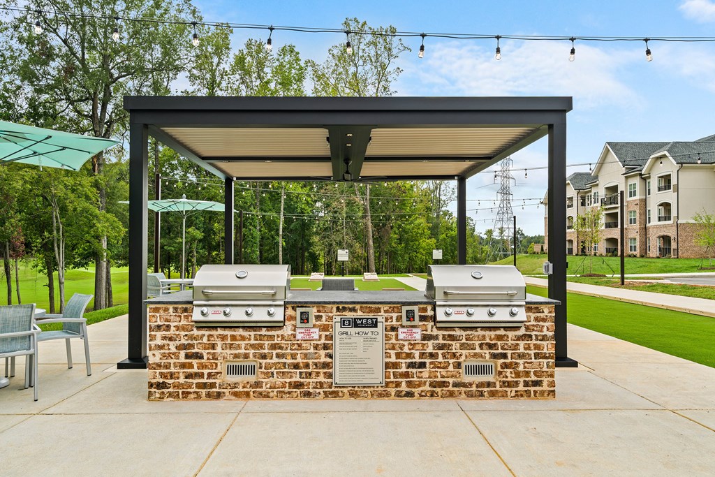 a covered barbecue area with two bbq grills