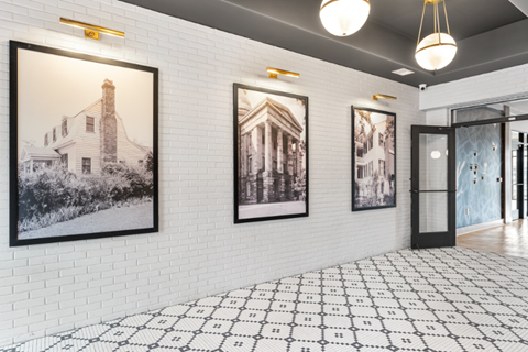 a lobby with three pictures on the wall and a glass door