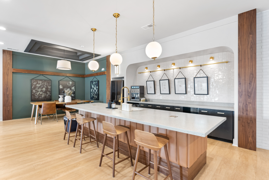 a large kitchen with a marble counter top and chairs