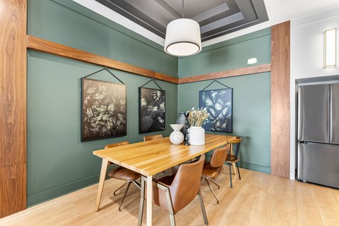 a dining room with a wooden table and chairs and a refrigerator