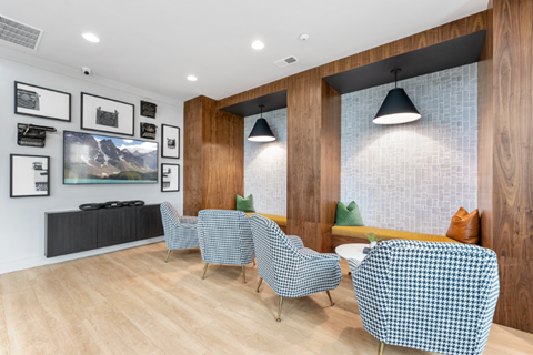 a living room with chairs and a table and a tv