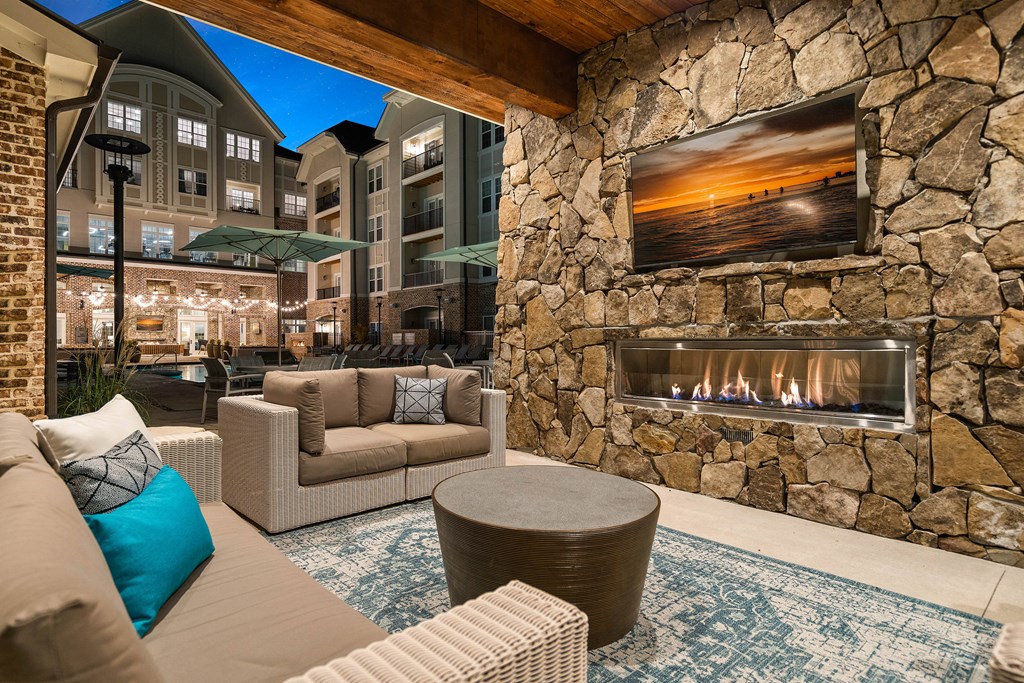 a living room with couches and a fireplace on a stone wall