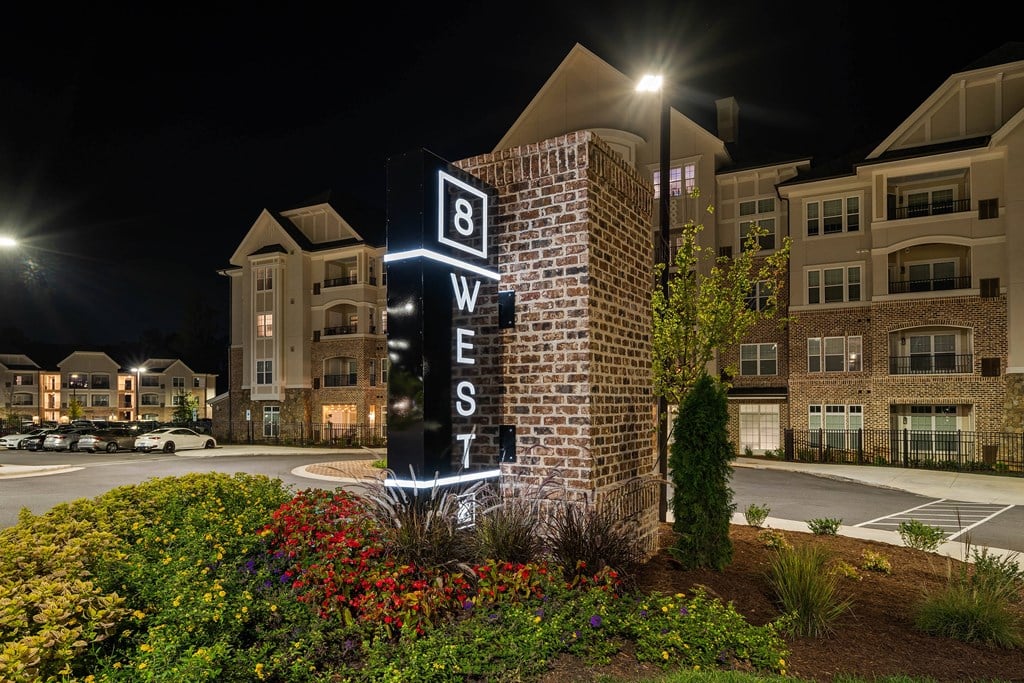 night time view of the dwellers sign in front of an apartment building
