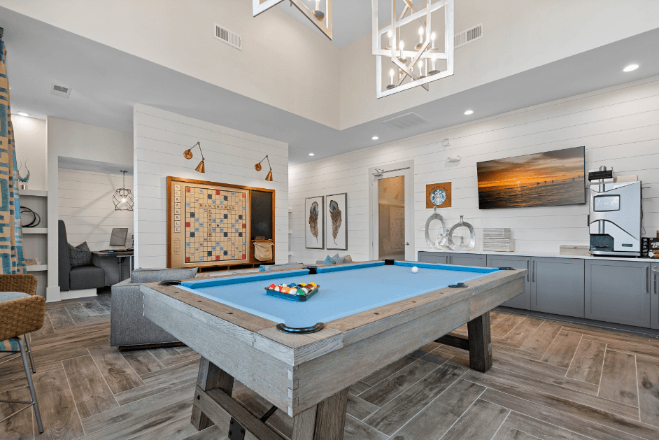 a pool table in a living room with a game system and a tv