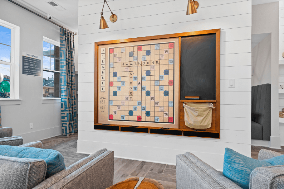 a living room with a bulletin board on the wall and couches and a television