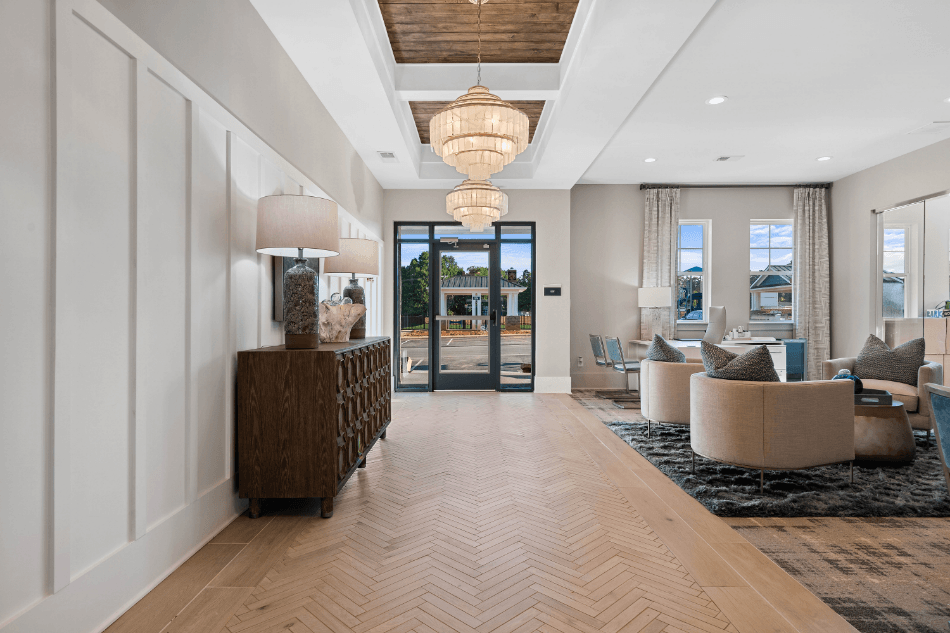a long hallway with couches and chairs and a door to a living room