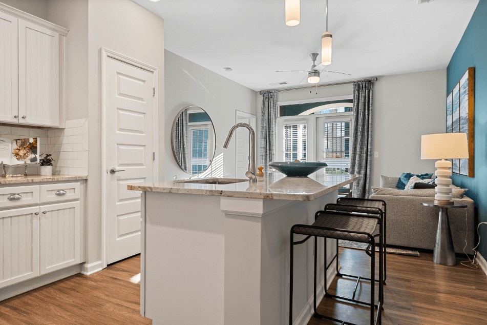 a kitchen with an island and stools next to a living room