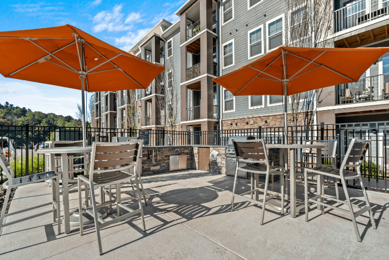 our apartments have a patio with tables and chairs and umbrellas