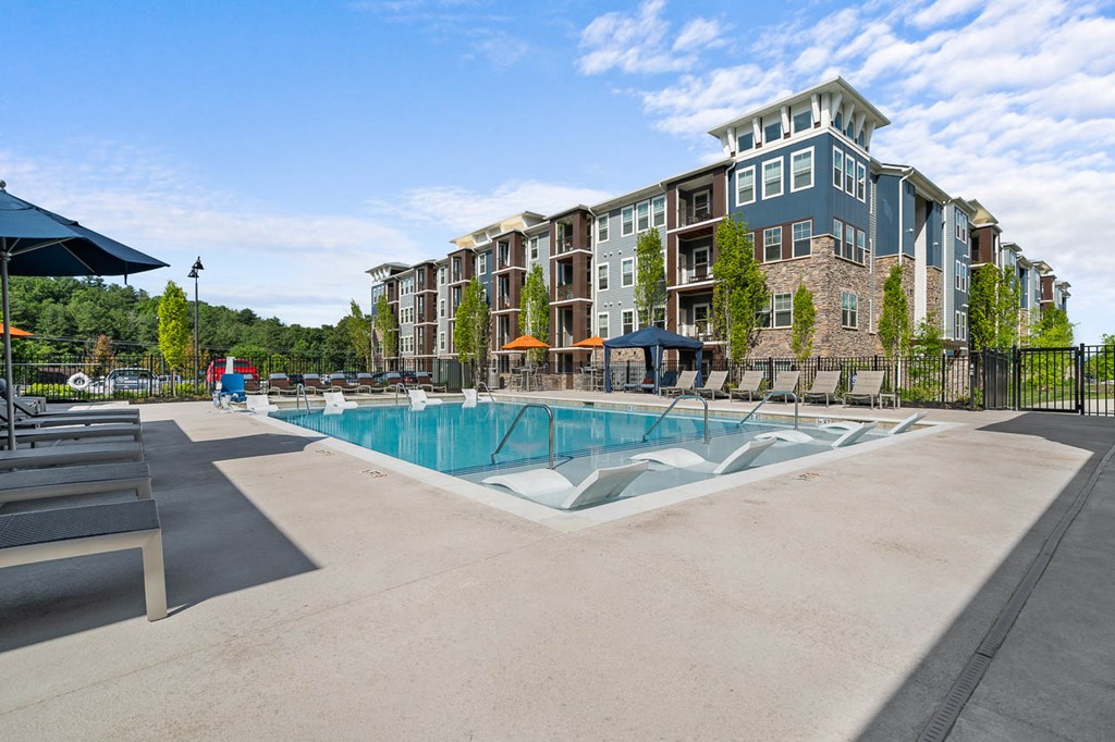 a pool with an apartment building in the background
