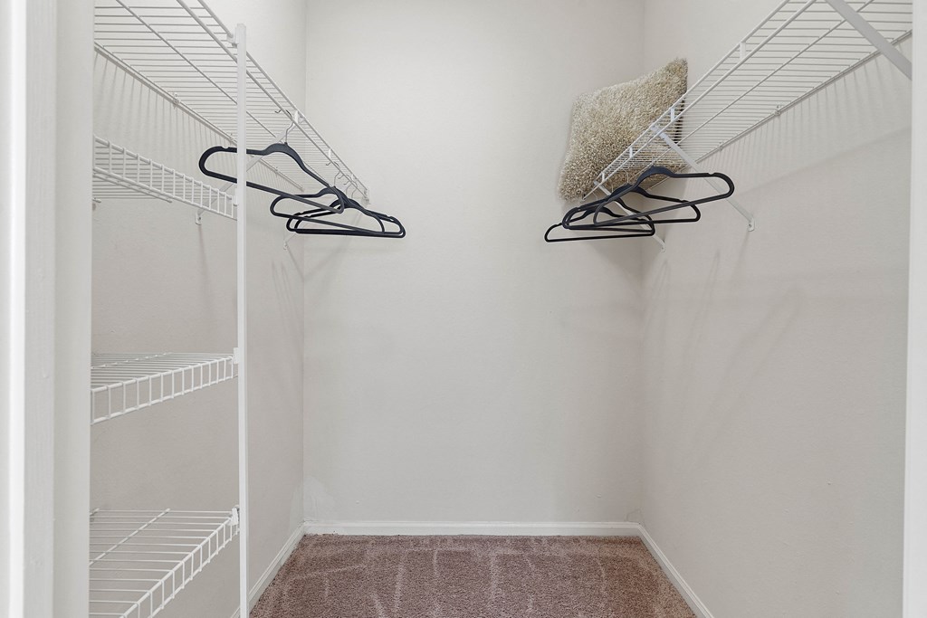 a walk in closet with two shoes hanging on the wall