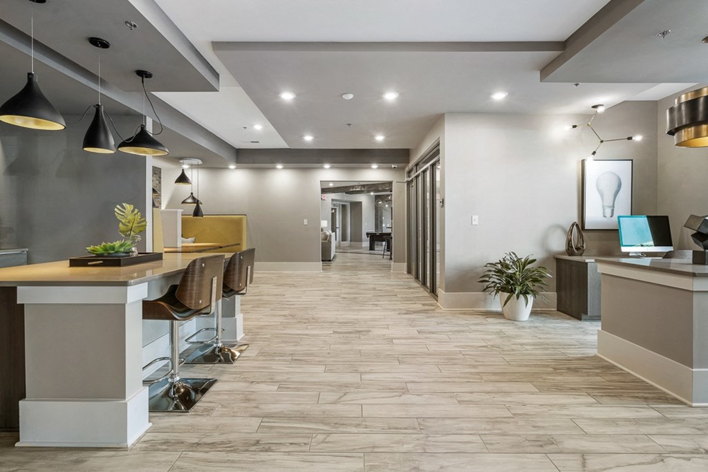 a large lobby with desks and chairs and a table with a laptop