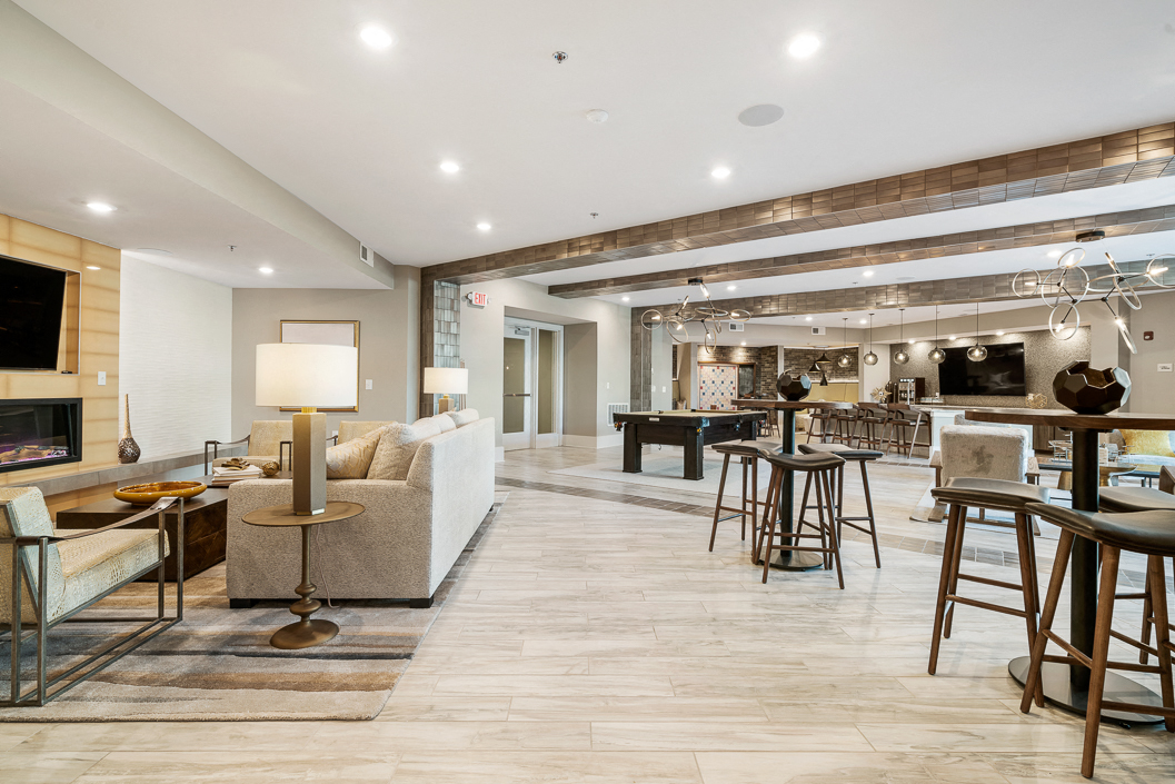 a living room with a fireplace and a dining room with tables and chairs