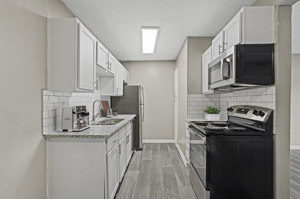 a kitchen with white cabinetry and black appliances