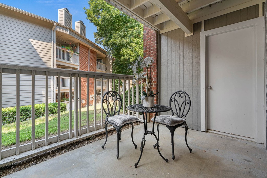 a patio with two chairs and a table on a balcony
