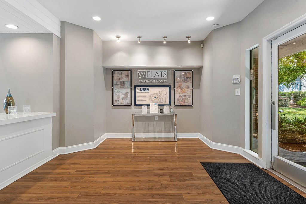 a room with a glass table in the middle of a wood floor