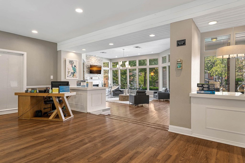 a living room with a desk and a lot of windows
