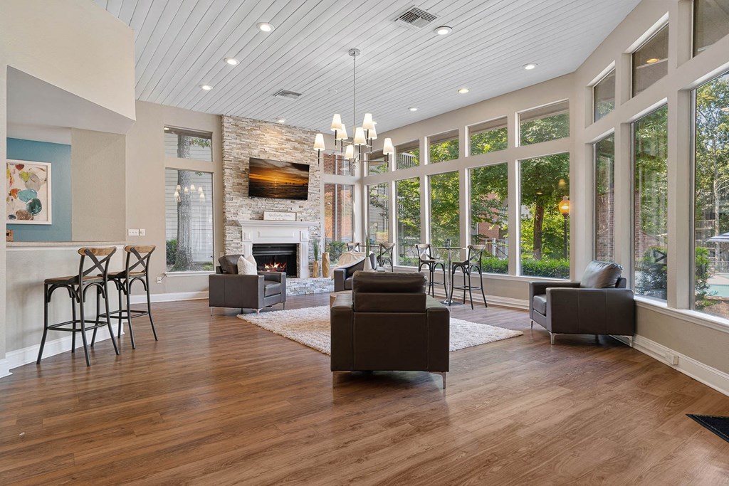 a living room with a fireplace and a large amount of windows