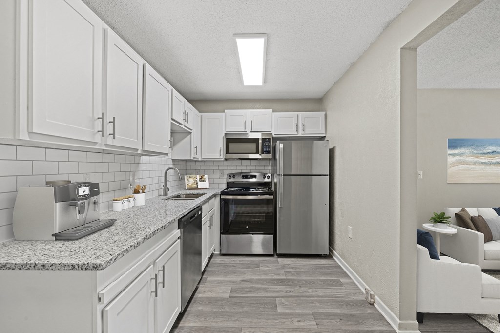 a kitchen with white cabinets and stainless steel appliances